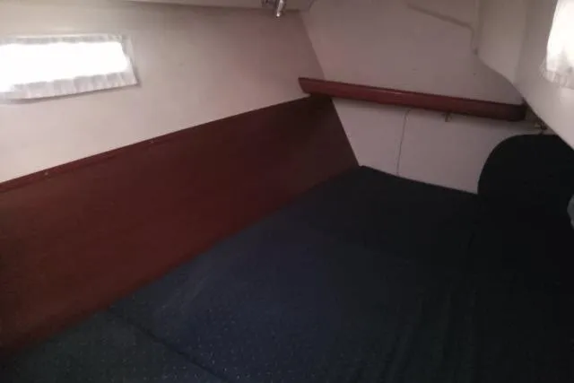 Slide: The Image of 2005 Beneteau 393 cabin interior with wooden paneling and bed. - 23