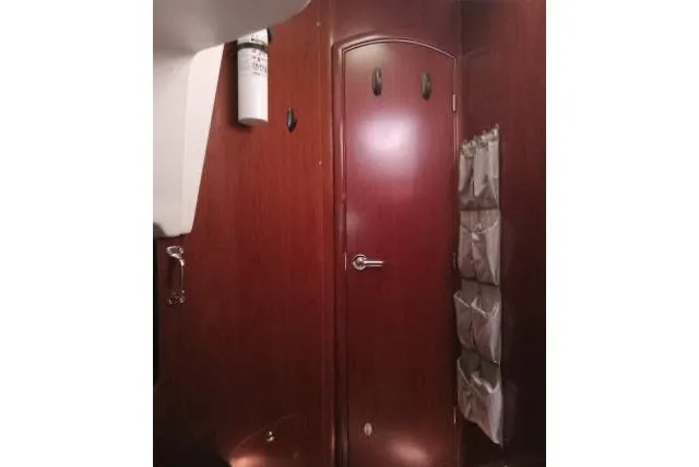 Slide: The Image of Interior of 2005 Beneteau 393 yacht with wooden door and storage pockets. - 24