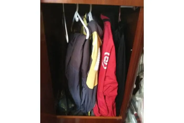 Slide: The Image of Clothes hanging in a wooden closet on a 2005 Beneteau 393 sailboat. - 25