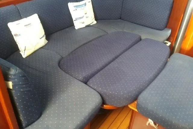 Slide: The Image of Interior seating of 2005 Beneteau 393 yacht with blue cushions and decorative pillows. - 3