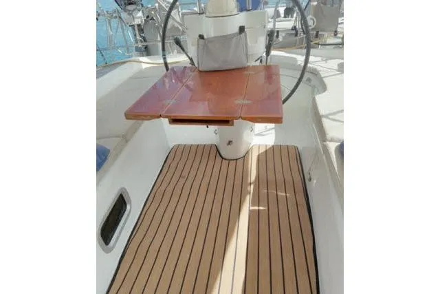 Slide: The Image of 2005 Beneteau 393 yacht cockpit with wooden table and striped flooring. - 32