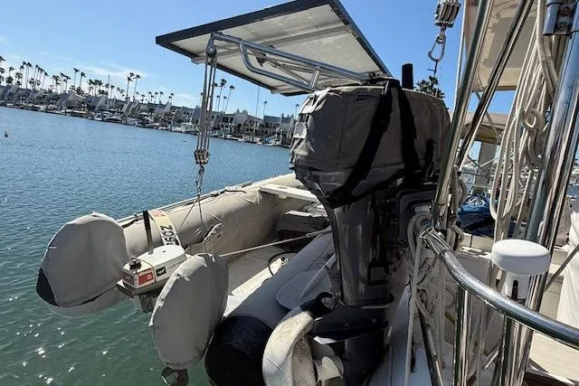 Slide: The Image of Beneteau 393 sailboat with outboard motor and dinghy, docked in a marina, 2005 model. - 40