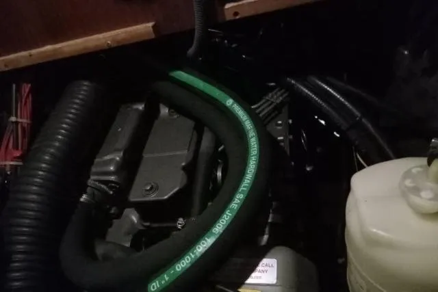 Slide: The Image of Engine compartment of a 2005 Beneteau 393 sailboat, featuring hoses and components. - 49