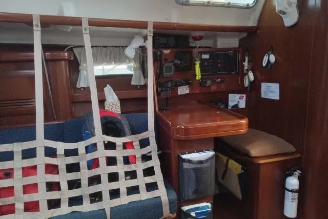 Slide: The Image of Interior of a 2005 Beneteau 393 sailboat with navigation station and seating area. - 5