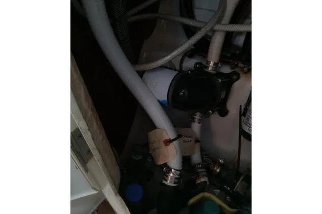 Slide: The Image of Engine compartment of a 2005 Beneteau 393 sailboat, showing hoses and mechanical components. - 51