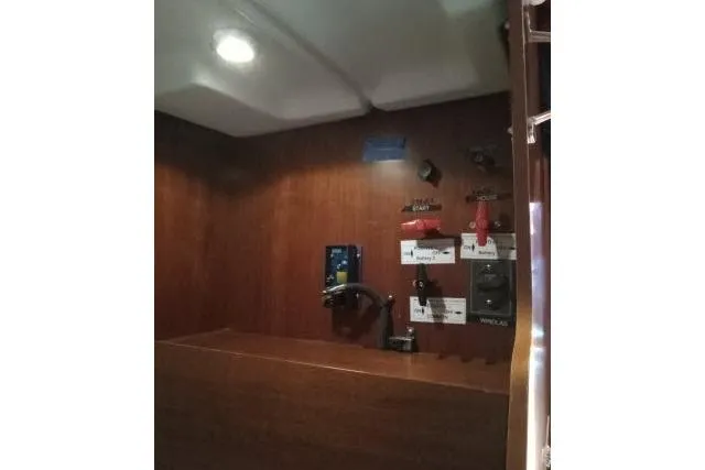 Slide: The Image of Control panel inside 2005 Beneteau 393 yacht, featuring switches and wooden interior. - 52