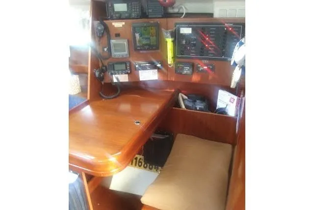 Slide: The Image of Navigation station inside 2005 Beneteau 393 yacht with communication equipment and wooden desk. - 6
