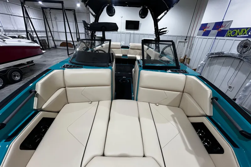 Slide: The Image of 2026 Moomba Tykon boat interior with beige seating and teal accents in a showroom. - 10
