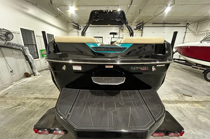 Slide: The Image of 2026 Moomba Tykon boat rear view in a garage setting. - 2