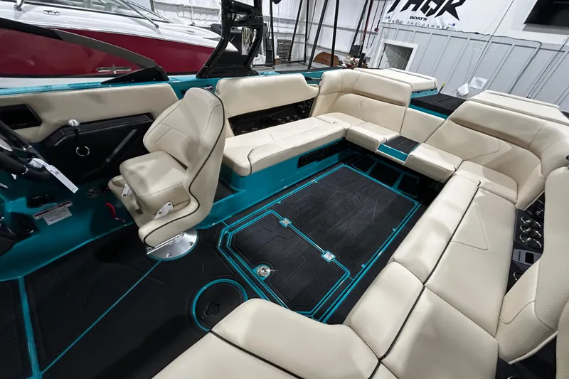 Slide: The Image of Interior of 2026 Moomba Tykon boat with beige seating and teal accents. - 8