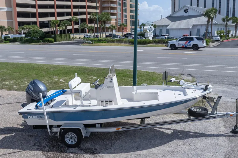 Slide: The Image of 2007 Pathfinder 2000 V boat on trailer, parked near a road with buildings in the background. - 12