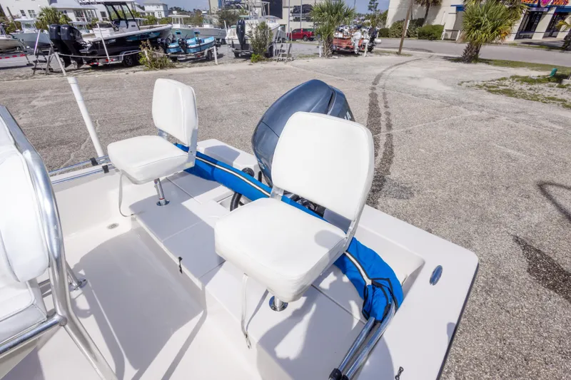 Slide: The Image of 2007 Pathfinder 2000 V boat with white seating and motor, parked outdoors. - 16