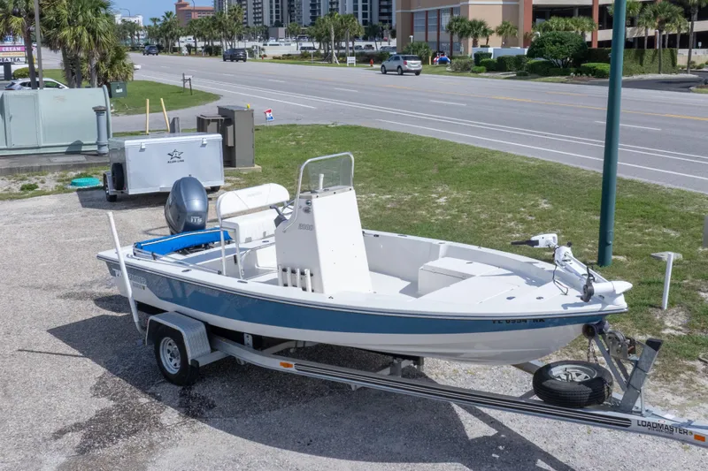 Slide: The Image of 2007 Pathfinder 2000 V boat on trailer, parked near a road with palm trees. - 4