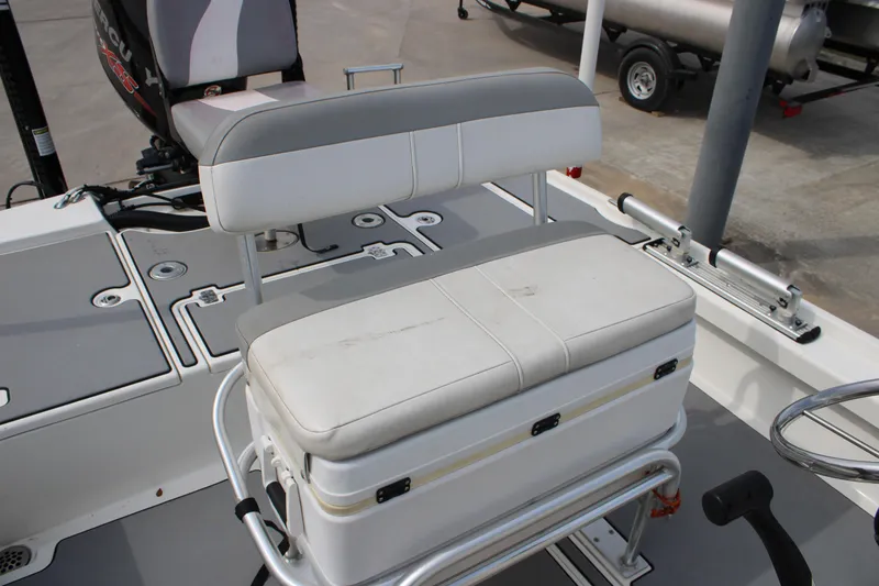Slide: The Image of 2018 Mako 21 LTS boat interior with cushioned seating and storage compartment. - 10