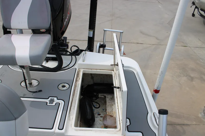 Slide: The Image of 2018 Mako 21 LTS boat interior with open storage compartment and seating. - 15