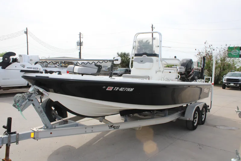 Slide: The Image of 2018 Mako 21 LTS boat on trailer, featuring Minn Kota trolling motor. - 2