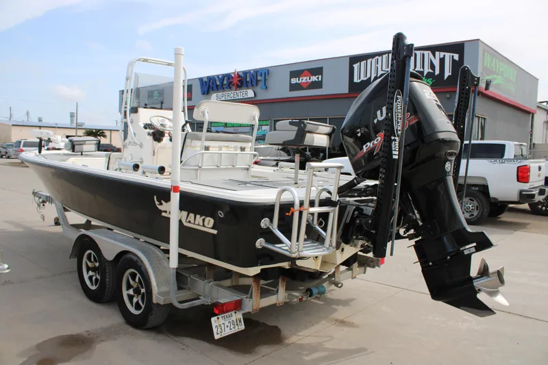 Slide: The Image of 2018 Mako 21 LTS boat on trailer at dealership, featuring powerful outboard motor. - 5