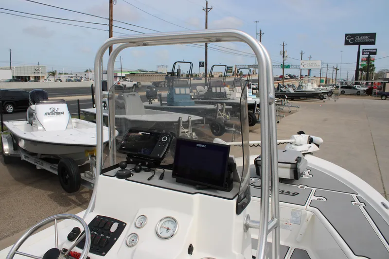 Slide: The Image of 2018 Mako 21 LTS boat dashboard with navigation equipment, parked in a dealership lot. - 9