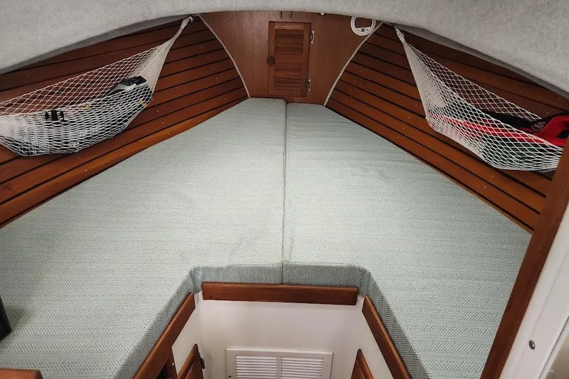 Slide: The Image of 2018 Acadia Atlas boat cabin with wooden interior and netted storage. - 8