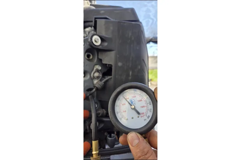 Slide: The Image of Hand holding pressure gauge near Ranger Z19 Comanche 2006 engine. - 11