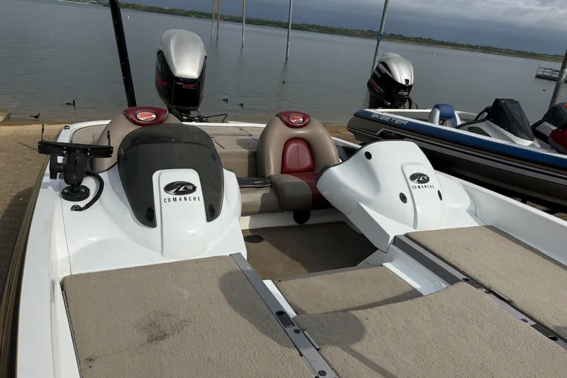 Slide: The Image of 2006 Ranger Z19 Comanche boat docked by the lake, featuring dual seats and motor. - 22