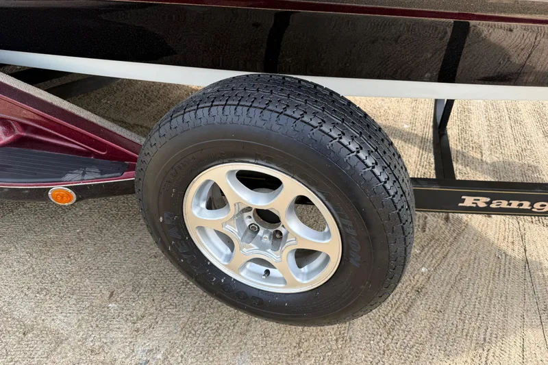 Slide: The Image of Trailer wheel of 2006 Ranger Z19 Comanche boat on concrete surface. - 23