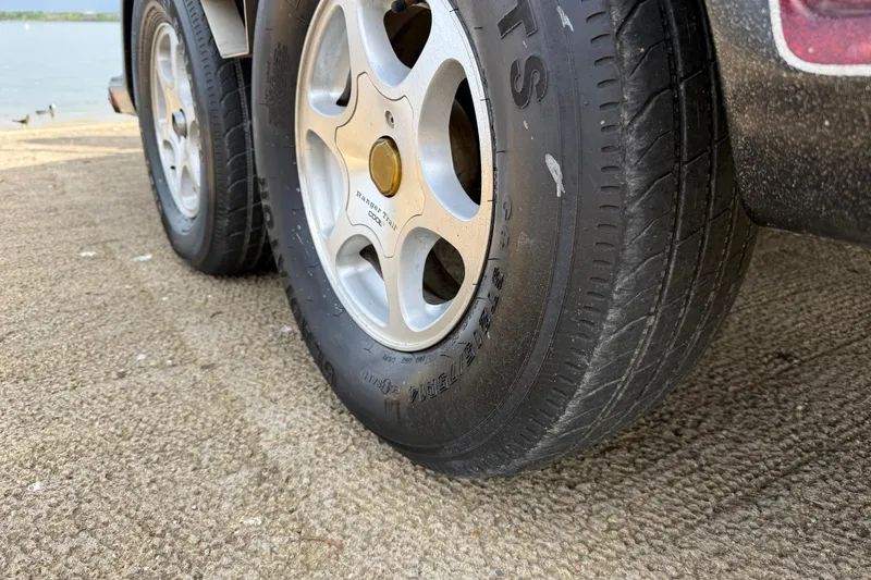 Slide: The Image of 2006 Ranger Z19 Comanche trailer tire on a concrete surface near water. - 24