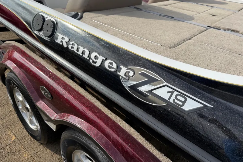 Slide: The Image of 2006 Ranger Z19 Comanche boat with maroon trailer, showcasing sleek design and branding. - 34