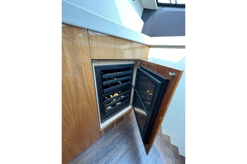 Slide: The Image of Wine cooler in 2016 Sunseeker Manhattan 65 yacht interior, featuring sleek wood paneling. - 23