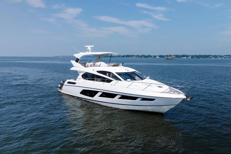 Slide: The Image of 2016 Sunseeker Manhattan 65 yacht cruising on open water under a clear sky. - 3