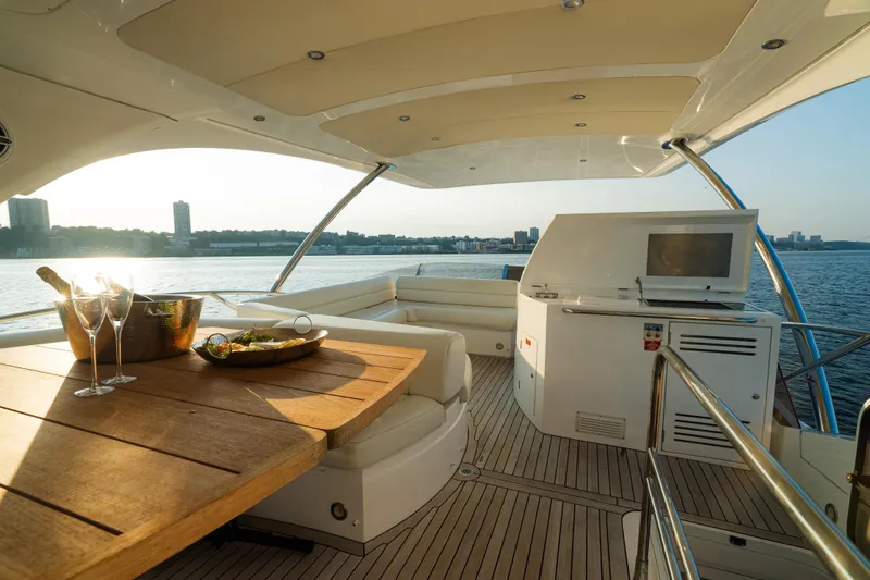 Slide: The Image of Luxurious 2016 Sunseeker Manhattan 65 yacht interior with dining area and scenic waterfront view. - 40