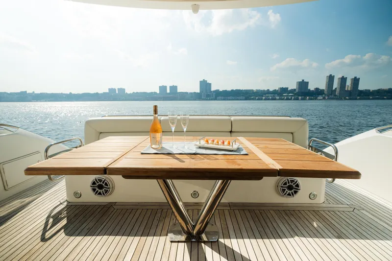 Slide: The Image of Luxury Sunseeker Manhattan 65 yacht deck with table, champagne, and waterfront view. - 7