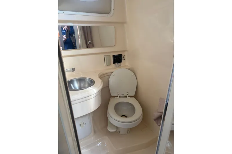 Slide: The Image of 2007 Larson Cabrio 260 boat bathroom with toilet, sink, and mirror. - 10
