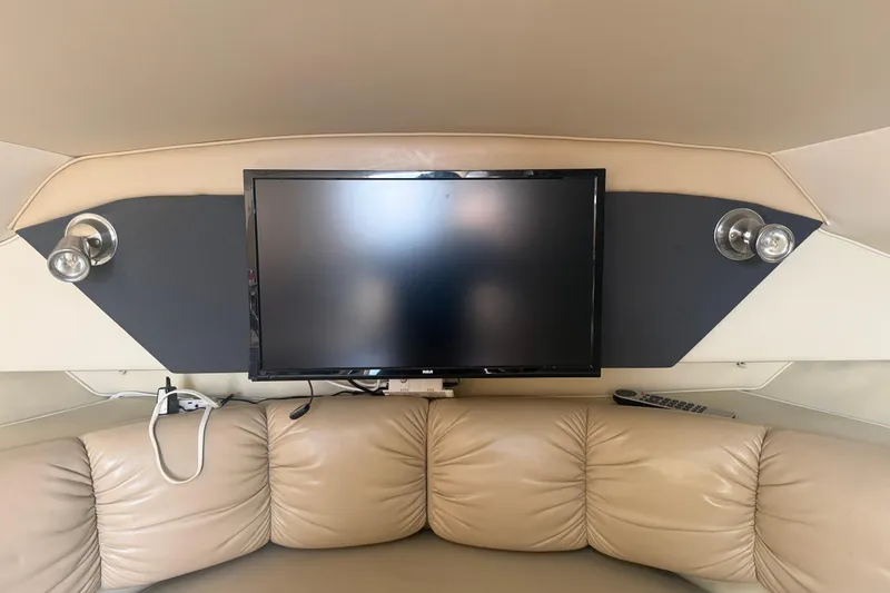 Slide: The Image of 2007 Larson Cabrio 260 interior with TV, beige seating, and wall-mounted lights. - 15