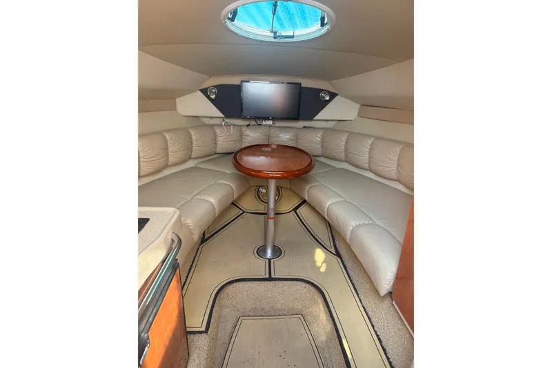 Slide: The Image of 2007 Larson Cabrio 260 cabin interior with plush seating and round table. - 16