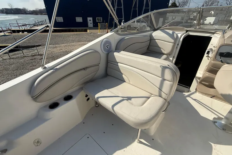 Slide: The Image of 2007 Larson Cabrio 260 boat interior with white seating and open cabin door. - 21