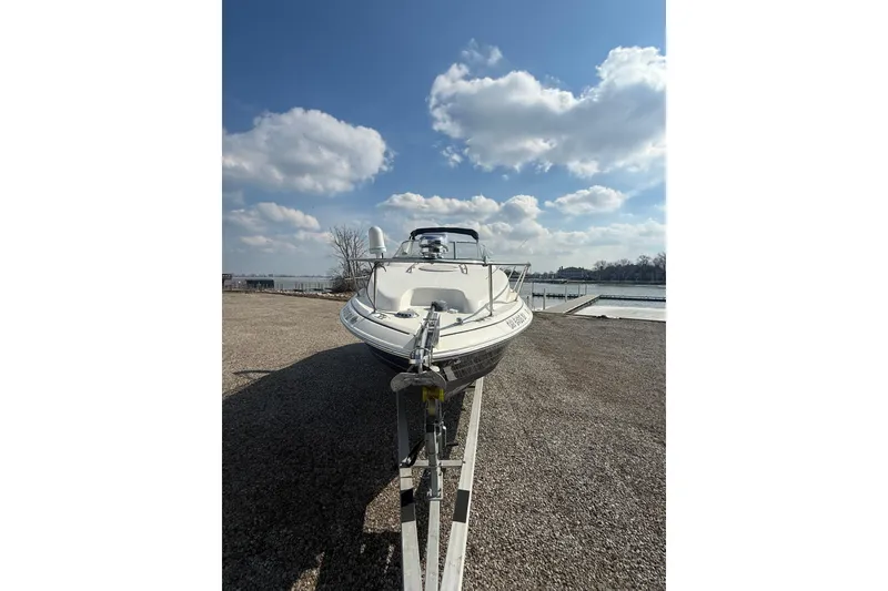 Slide: The Image of 2007 Larson Cabrio 260 boat on trailer under a bright blue sky. - 23