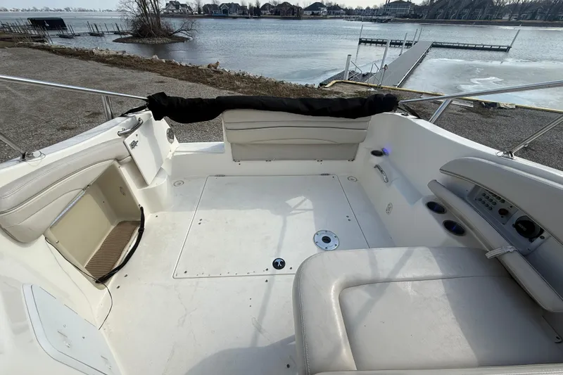 Slide: The Image of 2007 Larson Cabrio 260 boat interior with seating, overlooking a serene waterfront. - 7