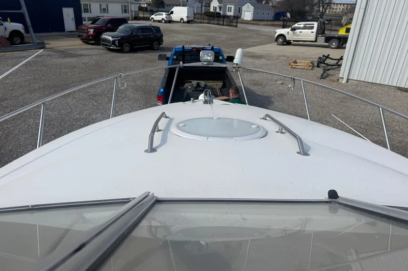 Slide: The Image of 2007 Larson Cabrio 260 boat on trailer, parked in a lot with vehicles nearby. - 9