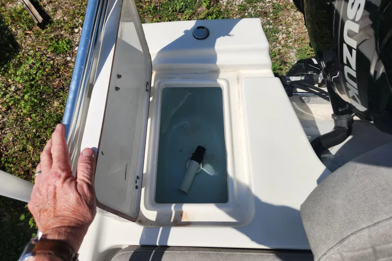 Slide: The Image of Open storage compartment on a 2021 Sea Pro 172 Bay boat with visible hand. - 10