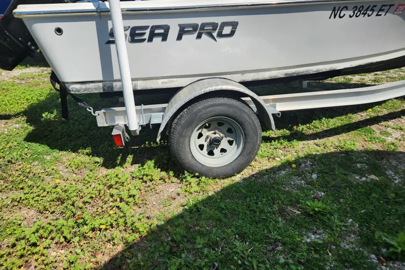Slide: The Image of 2021 Sea Pro 172 Bay boat on trailer, parked on grassy area. - 22