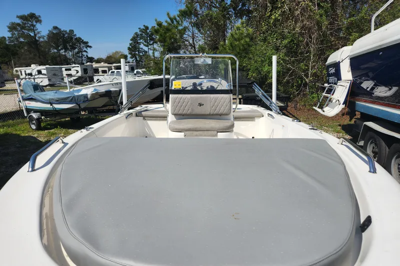 Slide: The Image of 2021 Sea Pro 172 Bay boat in storage, surrounded by trees and other boats. - 6