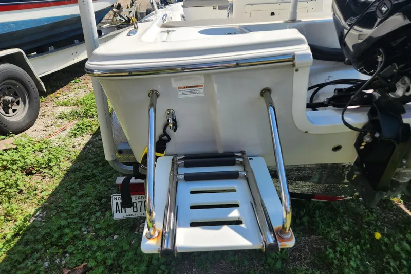 Slide: The Image of 2021 Sea Pro 172 Bay boat with rear swim ladder and motor, parked on grass. - 7