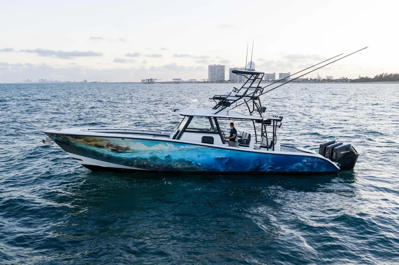 Slide: The Image of 2023 Yellowfin 42 Offshore boat on ocean, featuring vibrant marine-themed hull design. - 1