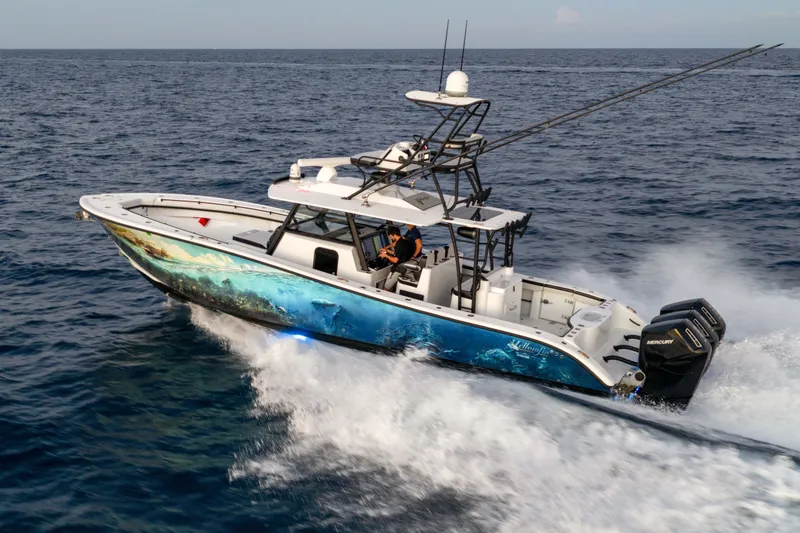 Slide: The Image of 2023 Yellowfin 42 Offshore boat cruising on open ocean with vibrant hull design. - 10