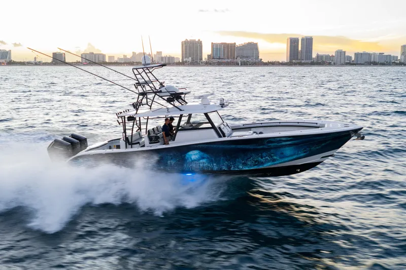 Slide: The Image of 2023 Yellowfin 42 Offshore boat cruising on ocean at sunset near city skyline. - 12