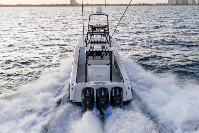 Slide: The Image of 2023 Yellowfin 42 Offshore boat cruising on open water, rear view. - 15