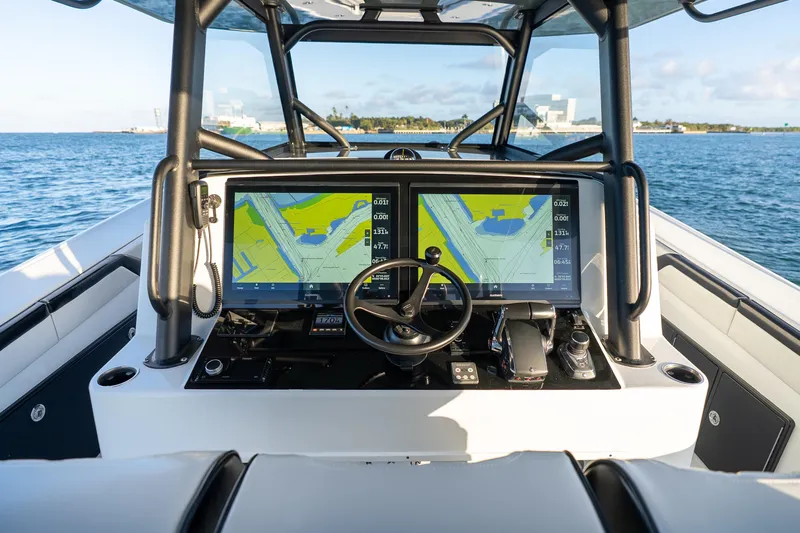 Slide: The Image of 2023 Yellowfin 42 Offshore boat helm with dual navigation screens on open water. - 18