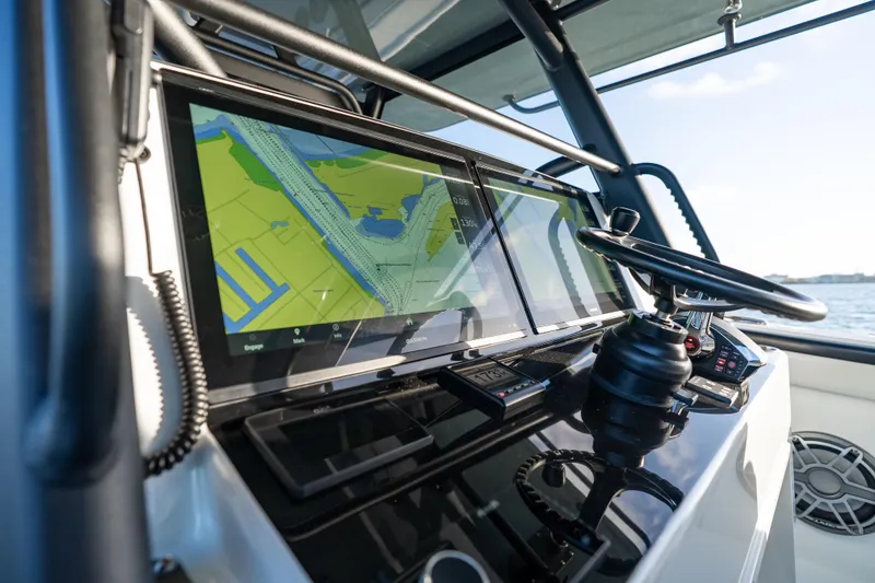 Slide: The Image of 2023 Yellowfin 42 Offshore boat dashboard with navigation screens and steering wheel. - 19