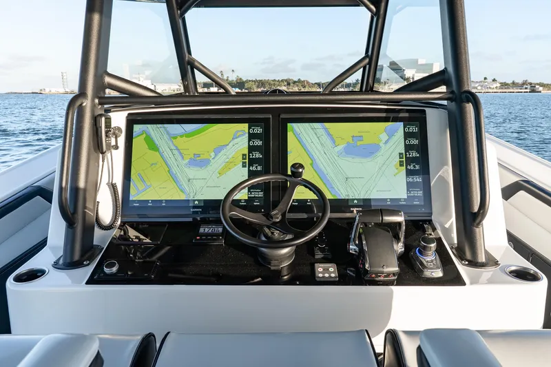 Slide: The Image of 2023 Yellowfin 42 Offshore boat dashboard with dual navigation screens and steering wheel. - 20